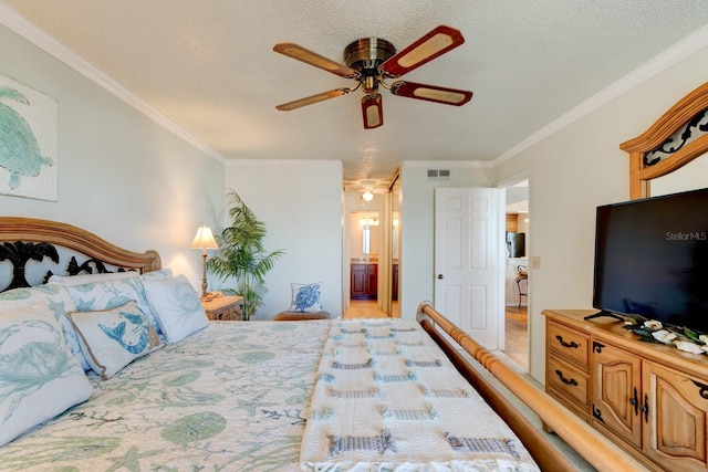 bedroom featuring connected bathroom, ornamental molding, a textured ceiling, and ceiling fan