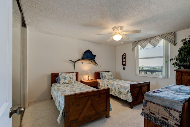 bedroom with light colored carpet, a textured ceiling, and ceiling fan