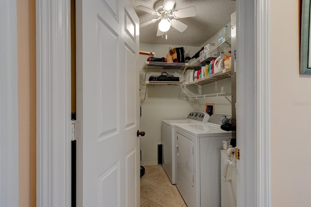 laundry room with light tile patterned floors, washer and dryer, and a textured ceiling