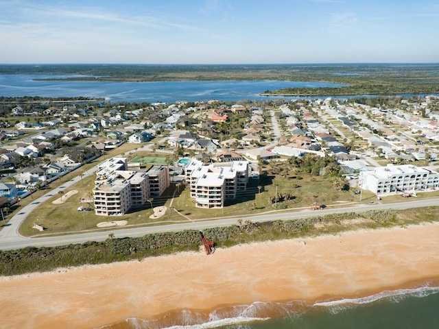 birds eye view of property with a water view and a beach view