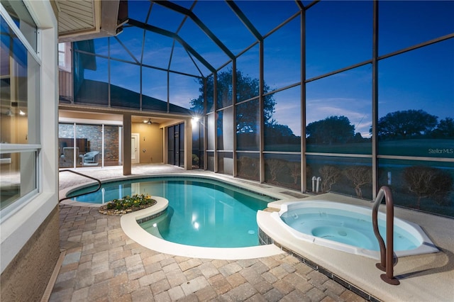 pool at dusk featuring an in ground hot tub, a patio, and glass enclosure