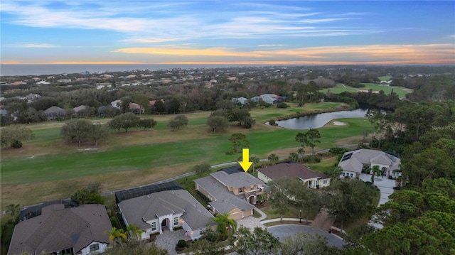 aerial view at dusk featuring a water view