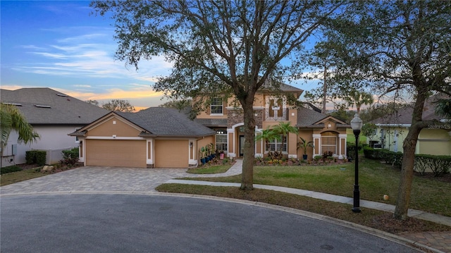 view of front of house featuring a garage and a yard