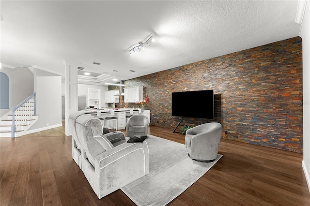 living room featuring dark wood-type flooring and a textured ceiling