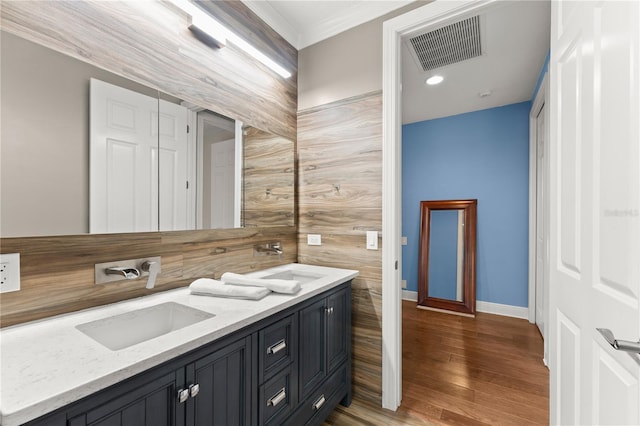 bathroom featuring vanity, wood-type flooring, and crown molding