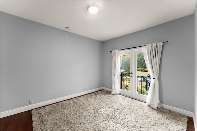 spare room with hardwood / wood-style flooring, a textured ceiling, and french doors