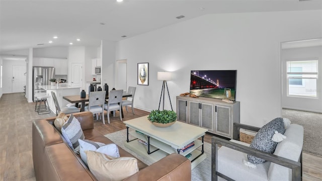 living room with lofted ceiling and light hardwood / wood-style flooring