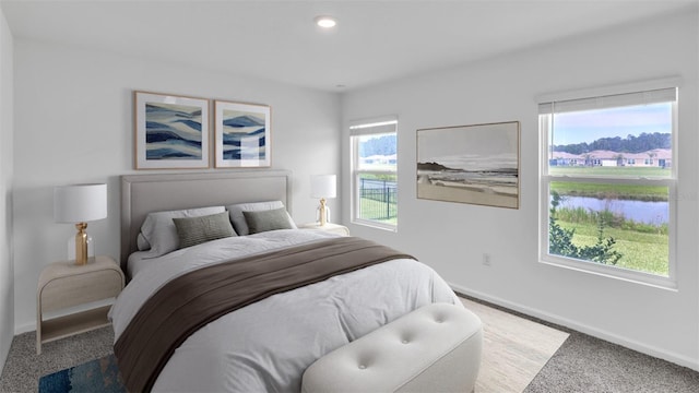 carpeted bedroom featuring a water view