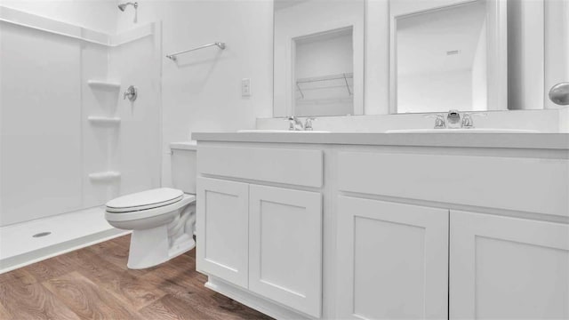 bathroom with walk in shower, wood-type flooring, toilet, and vanity