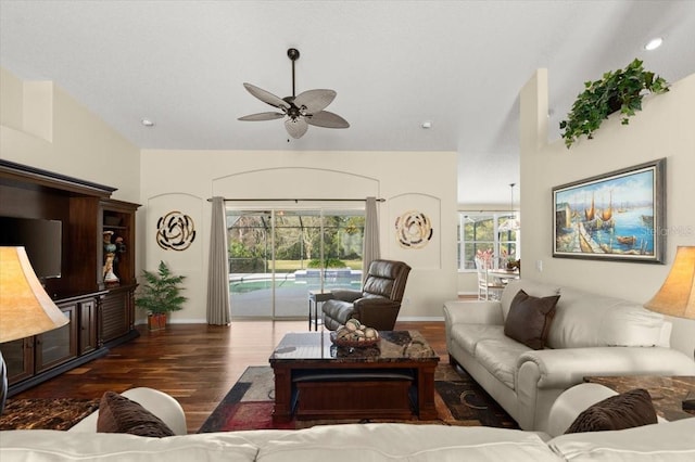 living room with dark wood-type flooring, ceiling fan, and vaulted ceiling