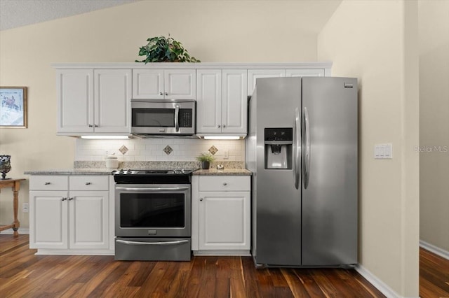 kitchen featuring lofted ceiling, appliances with stainless steel finishes, white cabinetry, backsplash, and dark hardwood / wood-style flooring