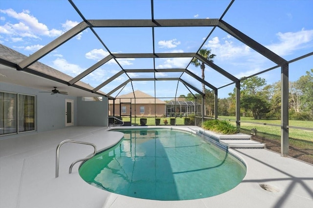 view of swimming pool with ceiling fan, a patio area, and glass enclosure