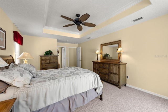 bedroom featuring crown molding, ceiling fan, a tray ceiling, a textured ceiling, and light colored carpet