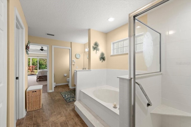 bathroom featuring toilet, separate shower and tub, a textured ceiling, hardwood / wood-style flooring, and ceiling fan