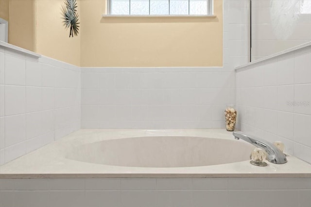 bathroom with a relaxing tiled tub and tile walls