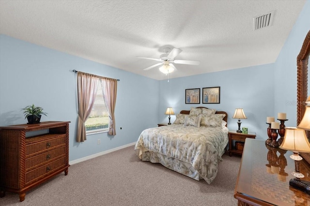 carpeted bedroom featuring ceiling fan and a textured ceiling