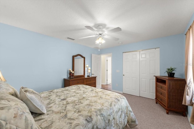 carpeted bedroom featuring ceiling fan and a closet