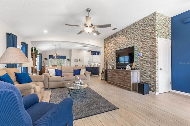 living room with lofted ceiling, a textured ceiling, ceiling fan, and light hardwood / wood-style flooring