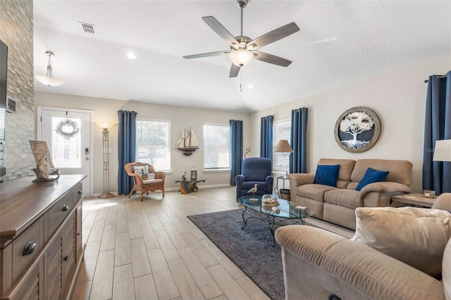 living room featuring ceiling fan, lofted ceiling, a textured ceiling, and light hardwood / wood-style floors