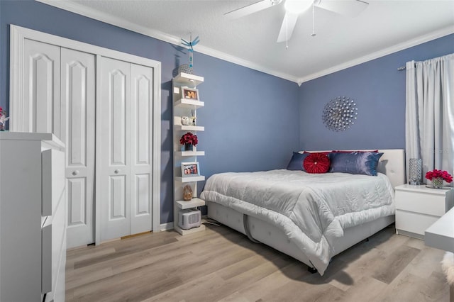 bedroom featuring crown molding, light hardwood / wood-style flooring, a textured ceiling, a closet, and ceiling fan