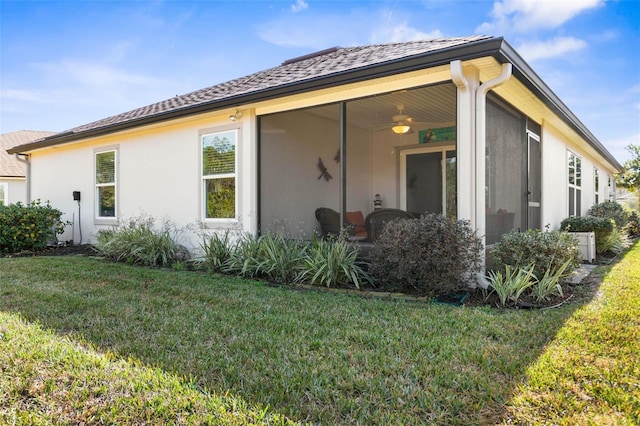 back of house featuring a yard, a sunroom, and ceiling fan