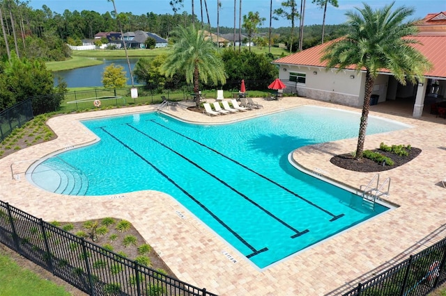 view of pool featuring a water view and a patio