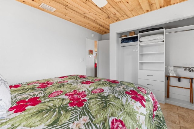 tiled bedroom featuring wood ceiling, an AC wall unit, and a closet