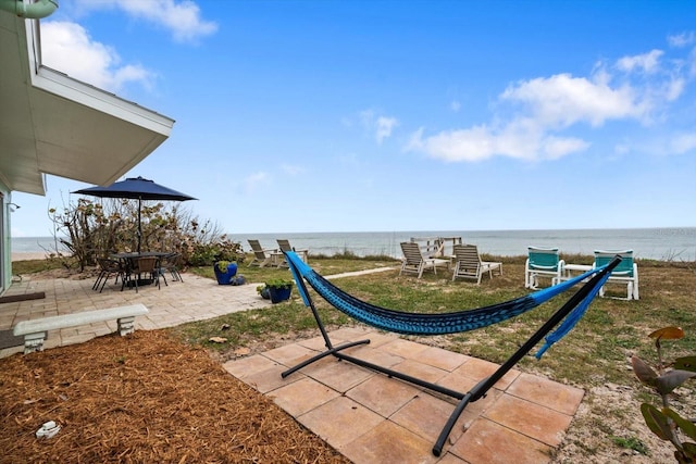 view of playground with a patio and a water view