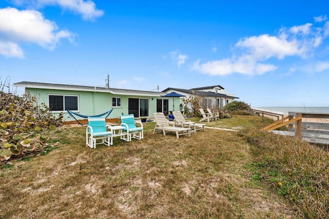 back of house featuring a water view and a yard