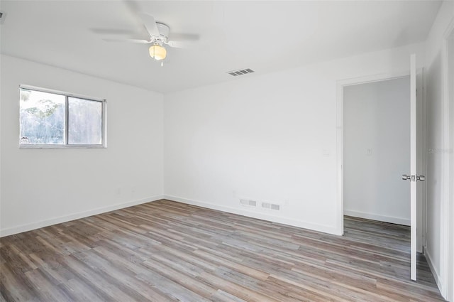 spare room with ceiling fan and light wood-type flooring