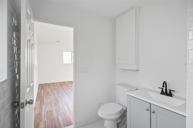 bathroom with hardwood / wood-style flooring, vanity, and toilet