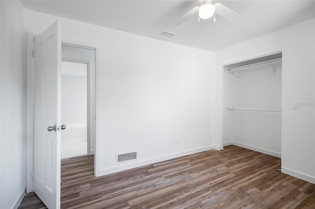 unfurnished bedroom featuring a closet, dark hardwood / wood-style floors, and ceiling fan