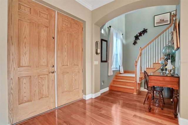 entrance foyer with crown molding and hardwood / wood-style floors