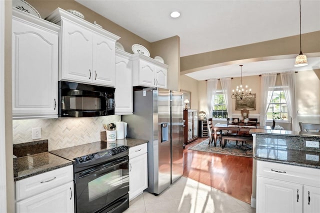 kitchen featuring an inviting chandelier, black appliances, hanging light fixtures, white cabinets, and backsplash