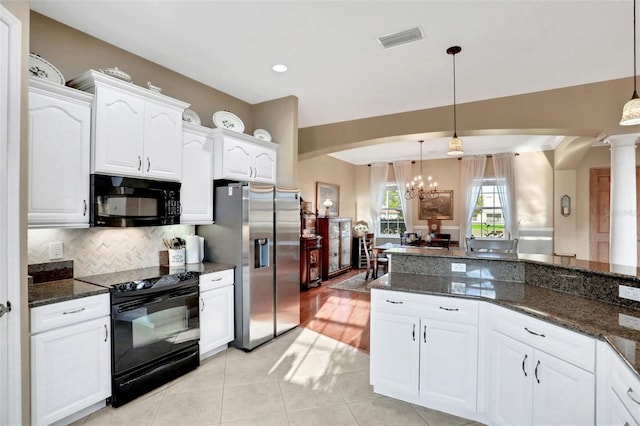 kitchen with white cabinetry, decorative light fixtures, dark stone countertops, and black appliances