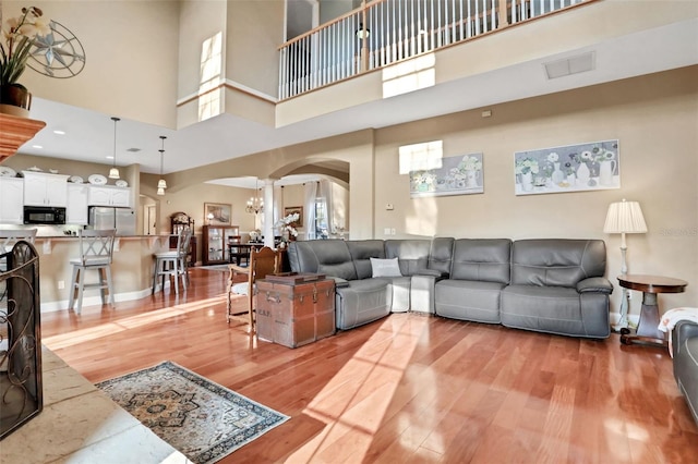 living room with a towering ceiling and light hardwood / wood-style floors