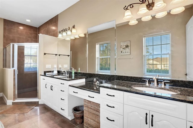 bathroom with a healthy amount of sunlight, an enclosed shower, tile patterned flooring, and vanity