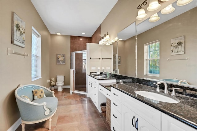 bathroom with vanity, toilet, tile patterned flooring, and a shower with door