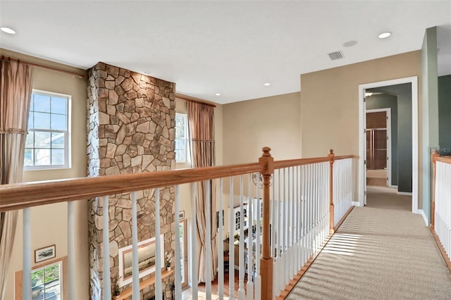 hall with plenty of natural light and light colored carpet