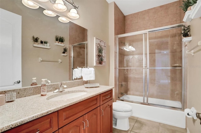 full bathroom with tile patterned flooring, vanity, bath / shower combo with glass door, and toilet