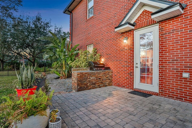 patio terrace at dusk with area for grilling and exterior kitchen