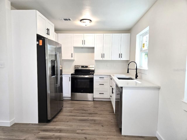 kitchen featuring stainless steel appliances, white cabinetry, and sink