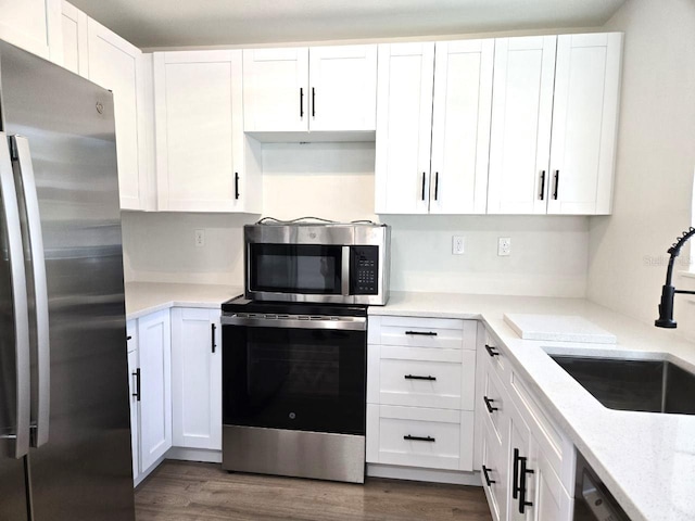 kitchen with stainless steel appliances, dark hardwood / wood-style floors, sink, and white cabinets