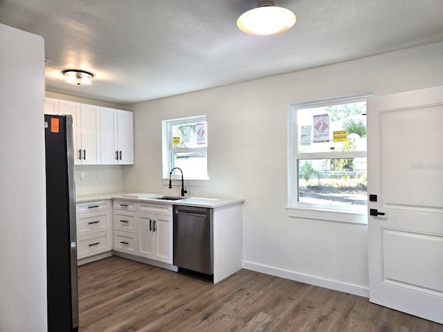 kitchen with sink, plenty of natural light, white cabinets, and appliances with stainless steel finishes