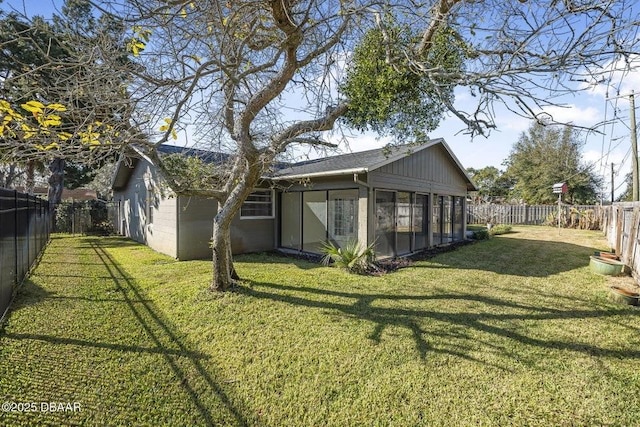 back of house featuring a sunroom and a lawn