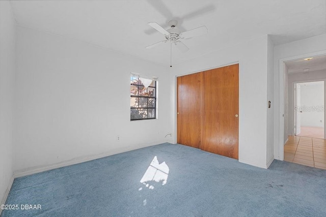 unfurnished bedroom with carpet floors, ceiling fan, and a closet