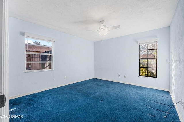 carpeted spare room featuring ceiling fan and a textured ceiling