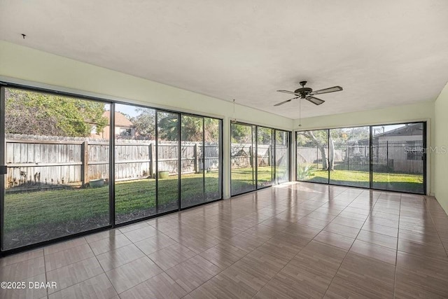 unfurnished sunroom with ceiling fan