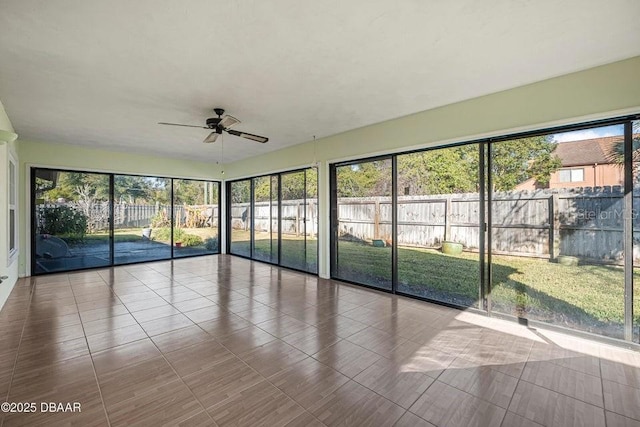 unfurnished sunroom featuring ceiling fan