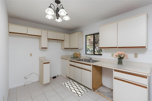 kitchen with light tile patterned flooring, decorative light fixtures, sink, a chandelier, and cream cabinets